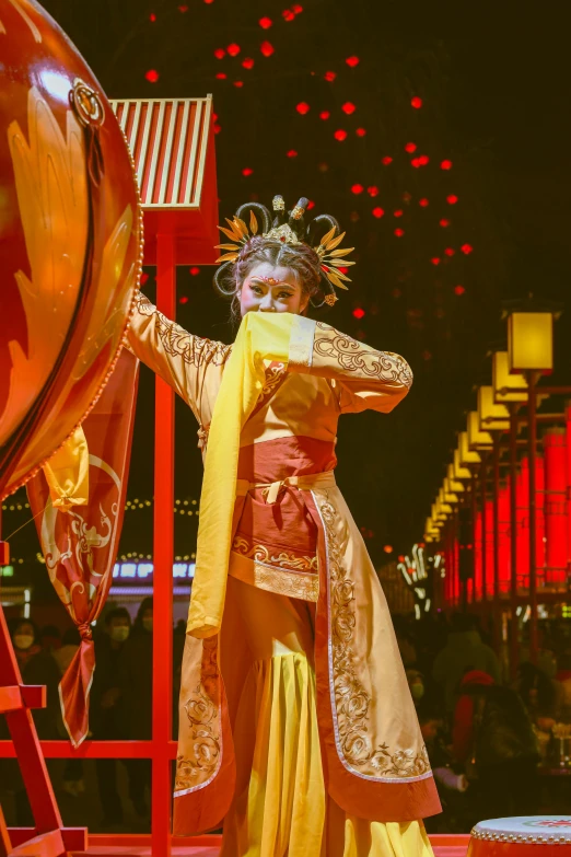 a woman is dressed in gold and wearing a costume