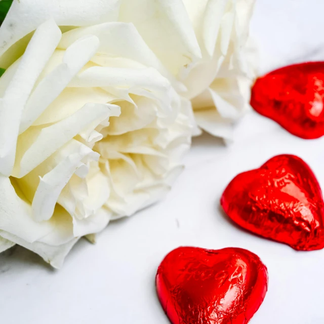 red and white hearts in front of some white flowers