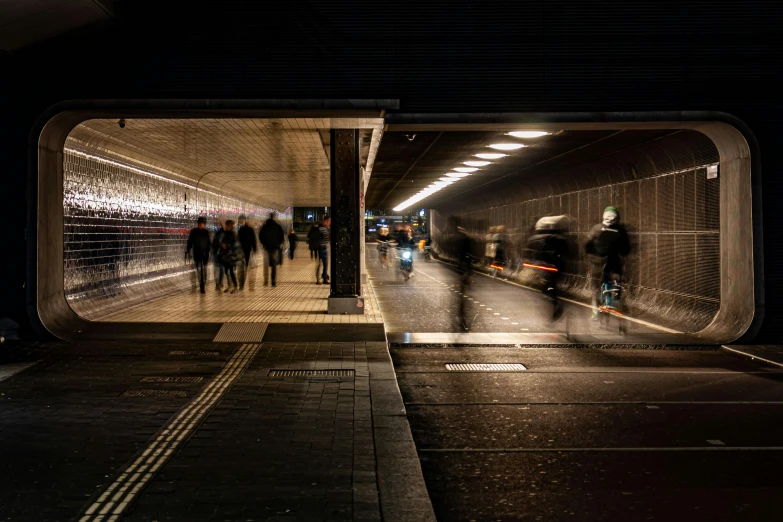 people stand in a subway at night near an exit way