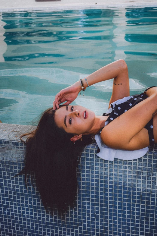the woman is posing in the pool