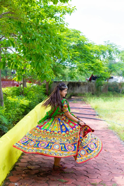 the girl in a colorful dress is leaning on the yellow wall