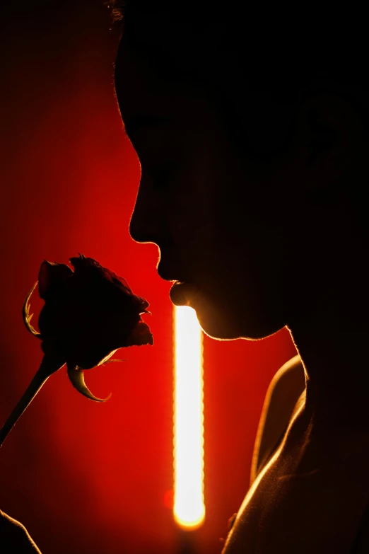 a person that is holding a rose in their mouth