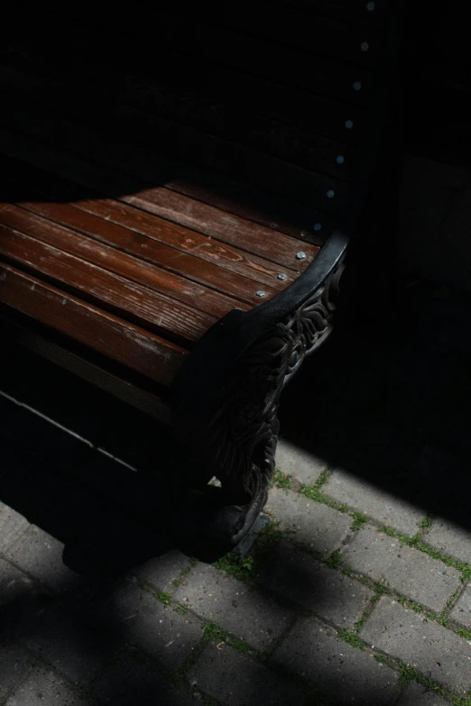 a shadow of a bench sitting on a sidewalk