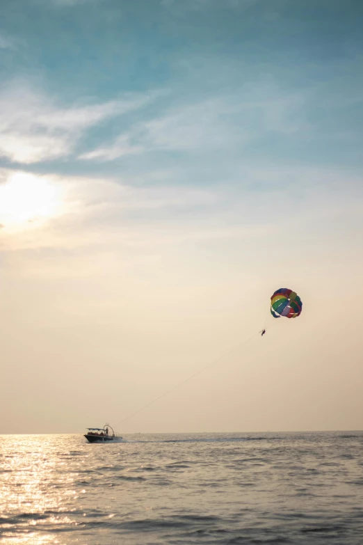 a boat and some kites in the air over the ocean