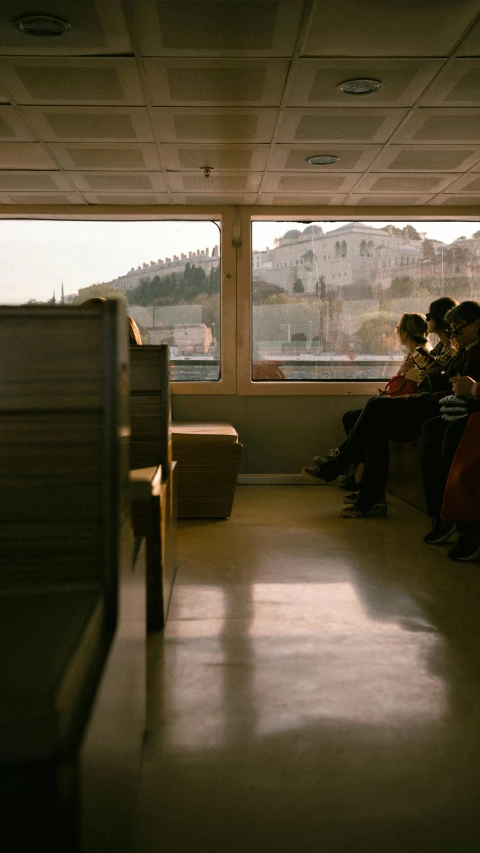 a row of people sitting on benches inside of a building