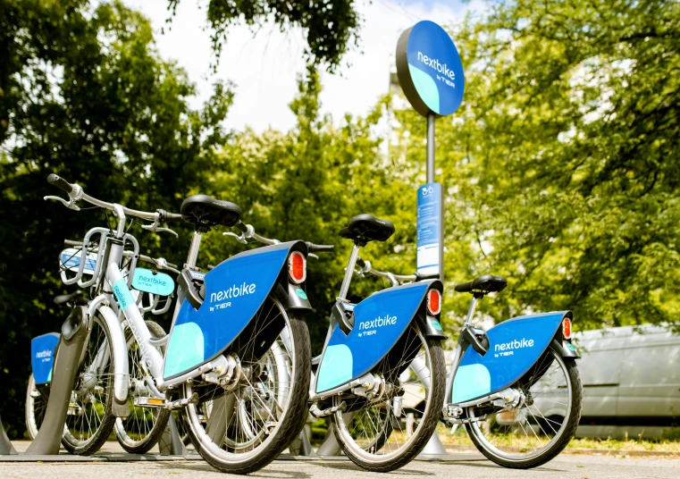 three bikes parked next to a blue bus