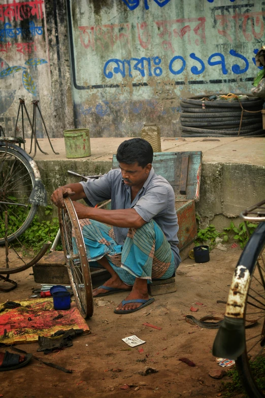 a man sitting down next to some vegetables