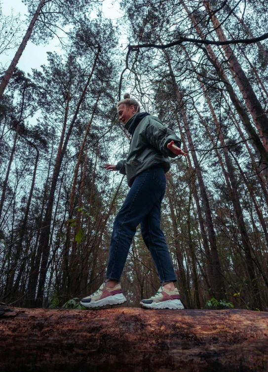 a man on a log in the woods