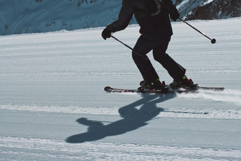 person in black jacket skiing on snowy slope with mountains in the background