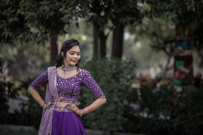 a woman is posing wearing an indian outfit