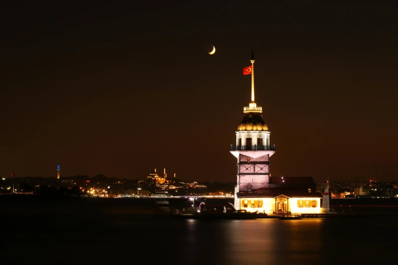 clock tower lit up in the evening along river