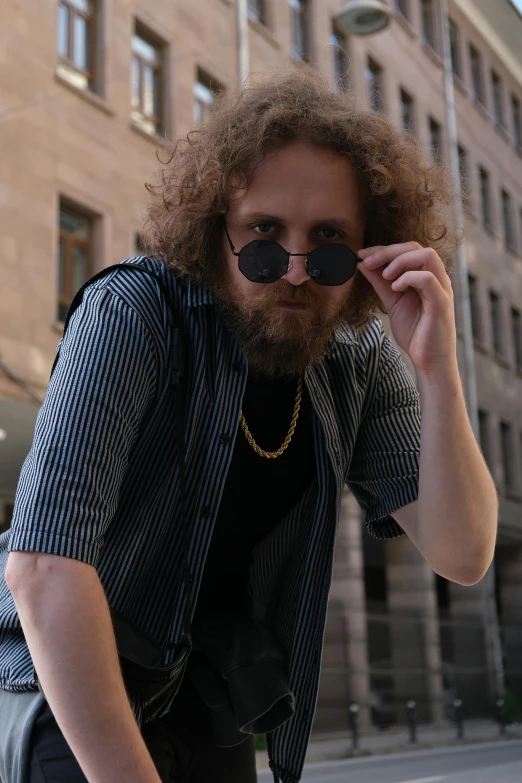 a bearded man wearing sunglasses in the middle of a street