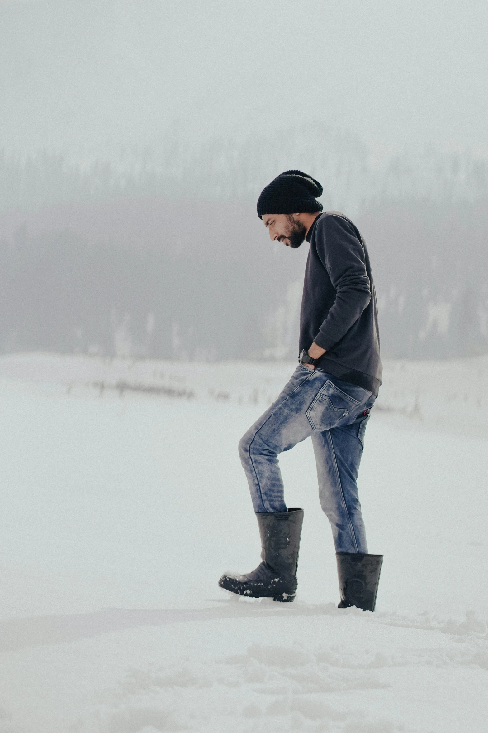 a man standing in the snow in his boots