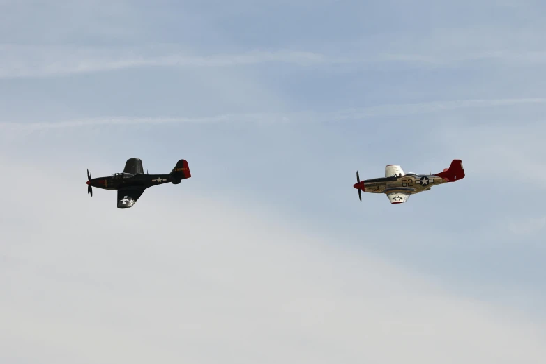 two small airplanes flying in the sky together