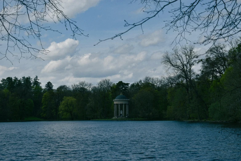 a very pretty lake with a gazebo by some trees