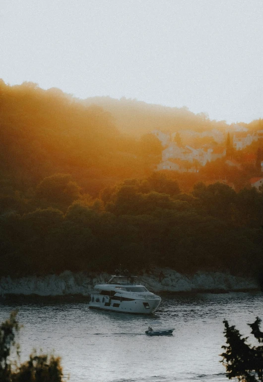 a boat is in the river with an orange sky