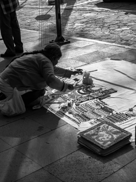 a person kneeling down next to some papers on the floor