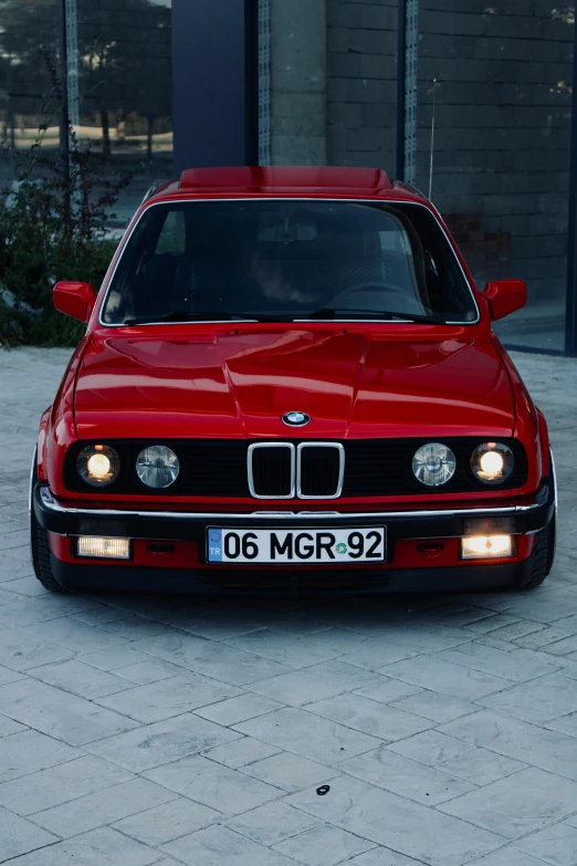 a red bmw is parked in a parking lot