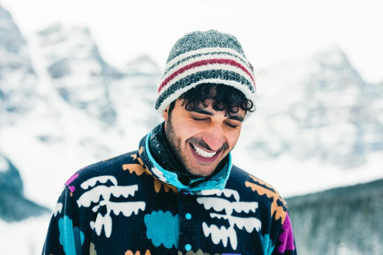 a young man in a patterned jacket laughing