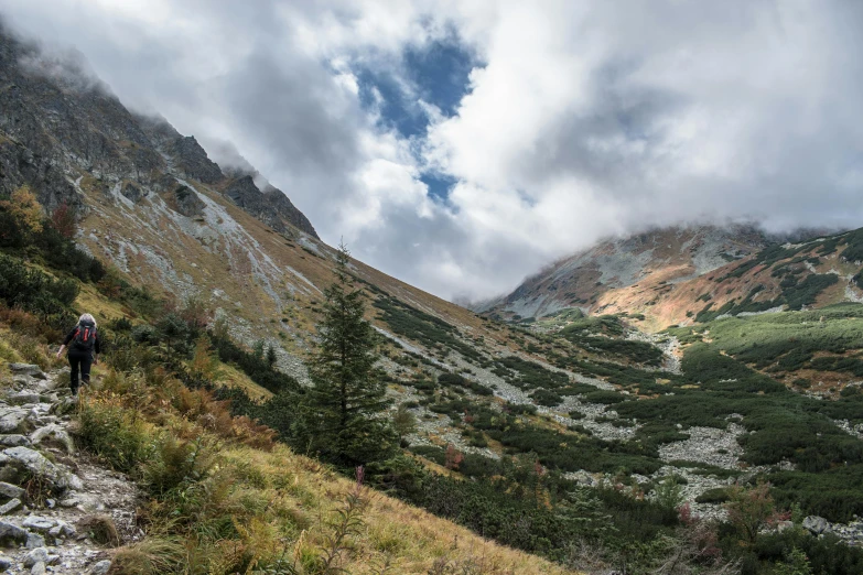 a lone hiker is descending the rocky trail