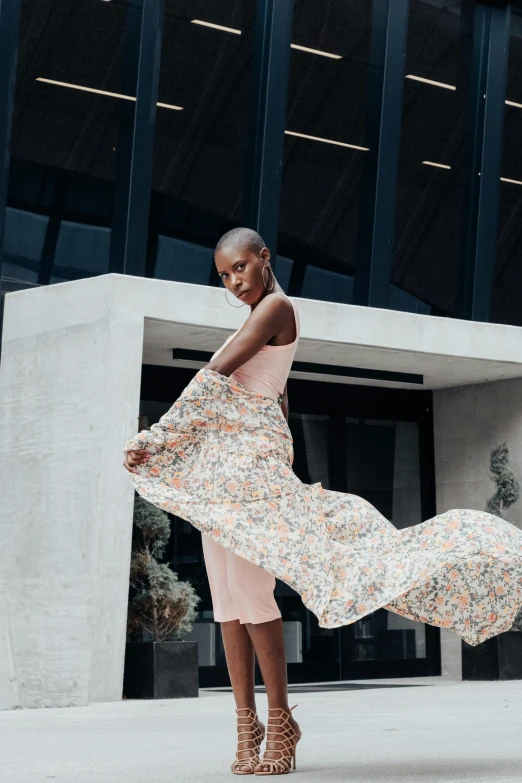 the woman is walking down the sidewalk in a dress