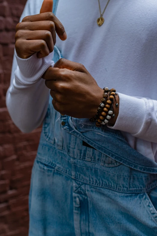 a woman is holding her hand together and some beads on her arm