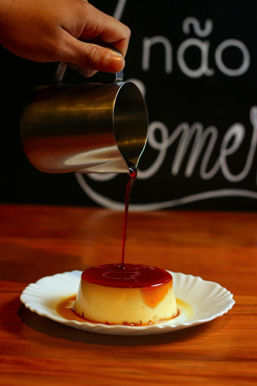 someone pours syrup onto a small white plate