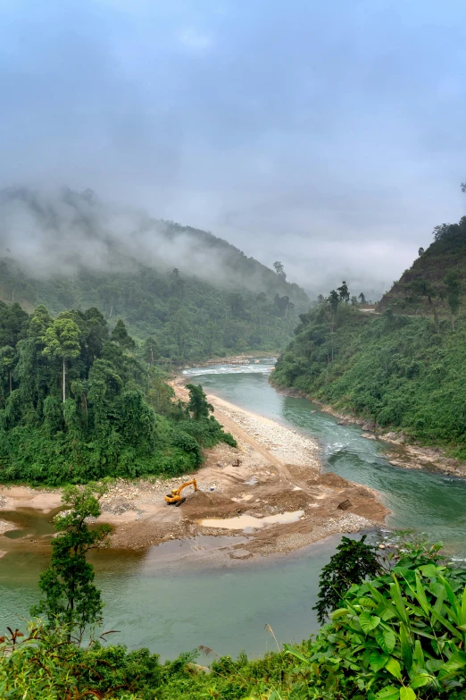 a body of water surrounded by mountains under clouds