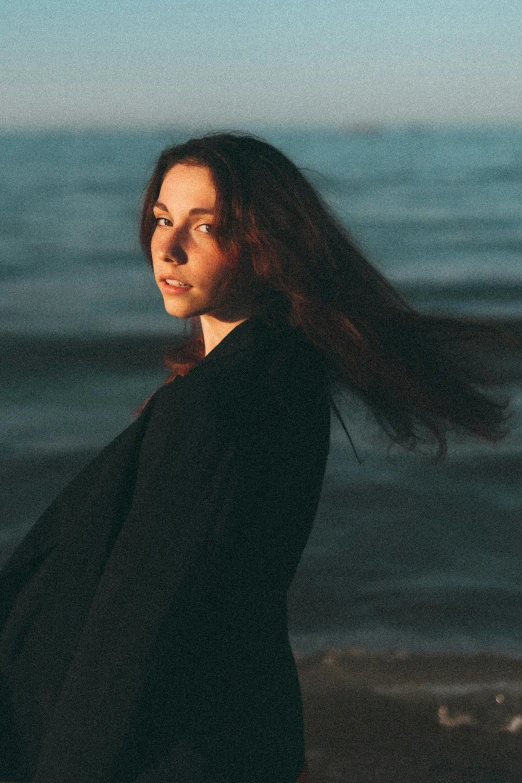 a woman standing on the beach and smiling