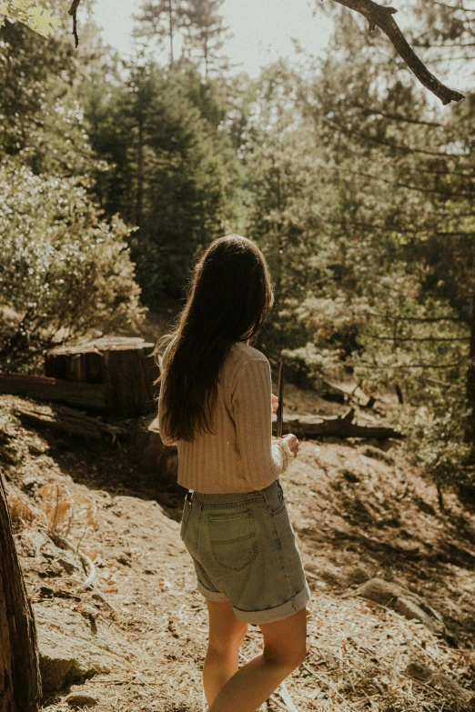 the woman in shorts is walking through the woods