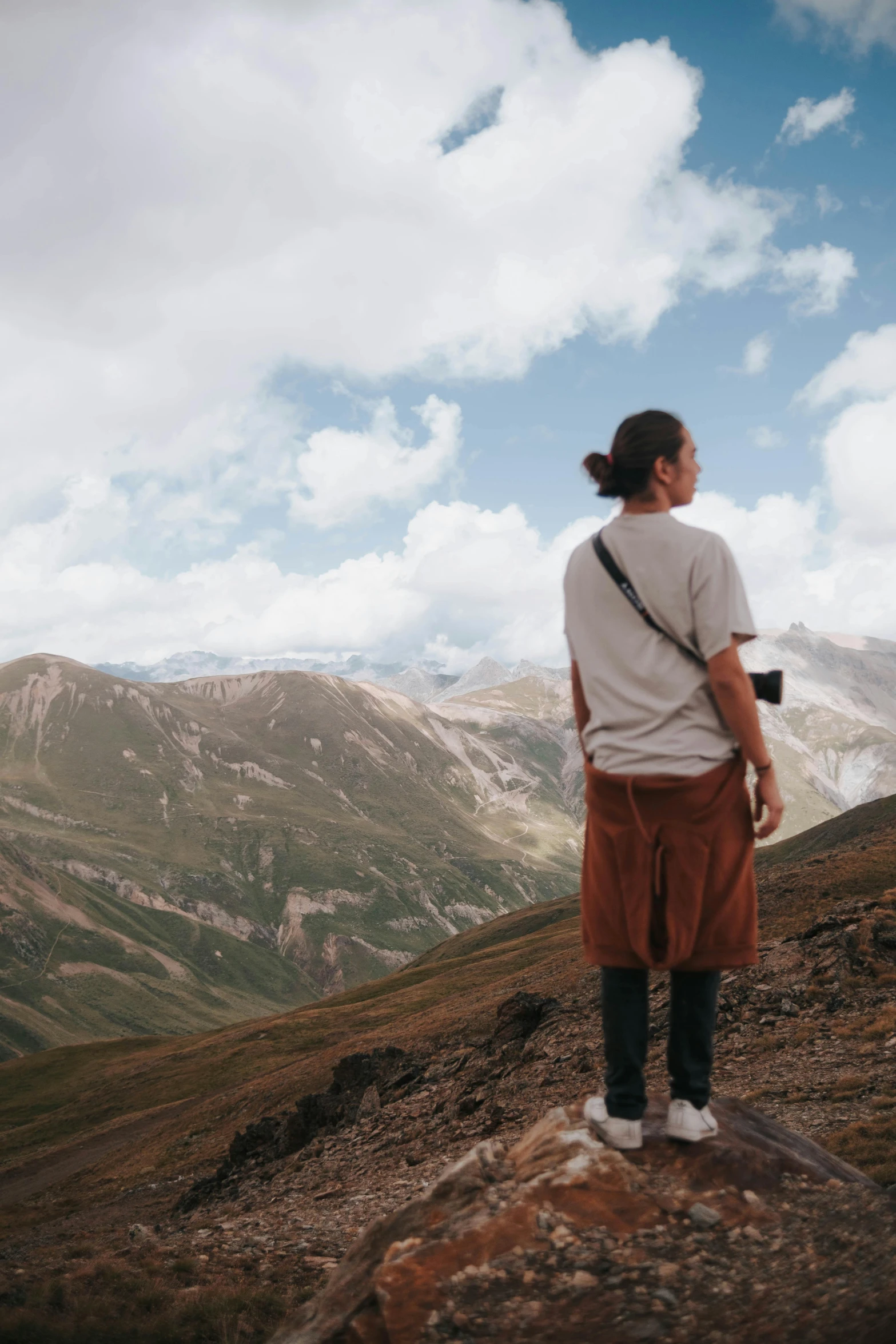 a person on a cliff overlooking mountains with a camera