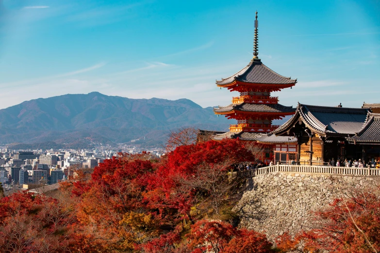 the pagoda has many spires above a city