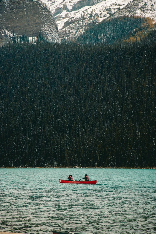 two people are paddling down a small boat