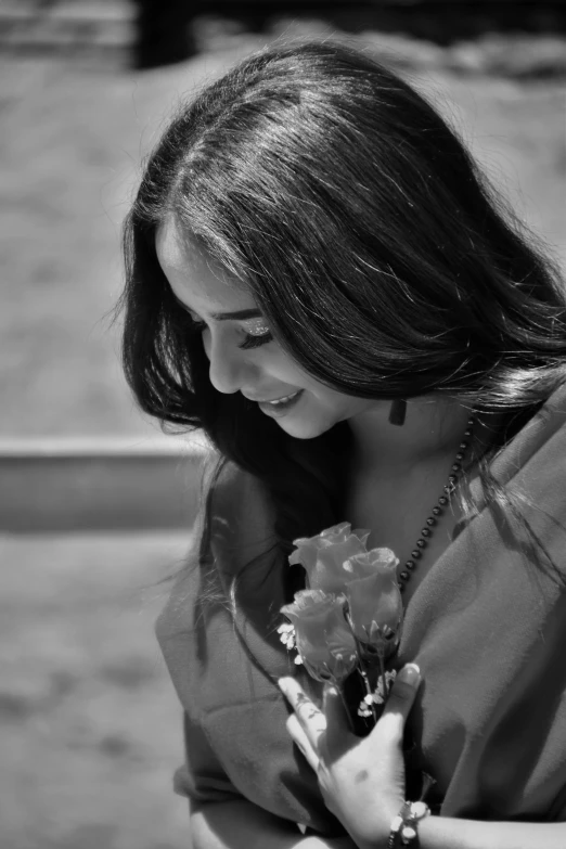 a black and white po of a woman holding a flower