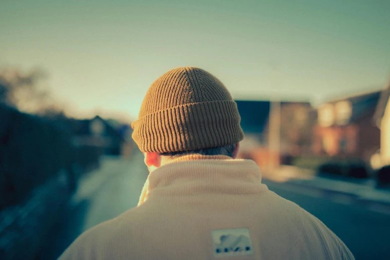 the back of a man in a beige hat