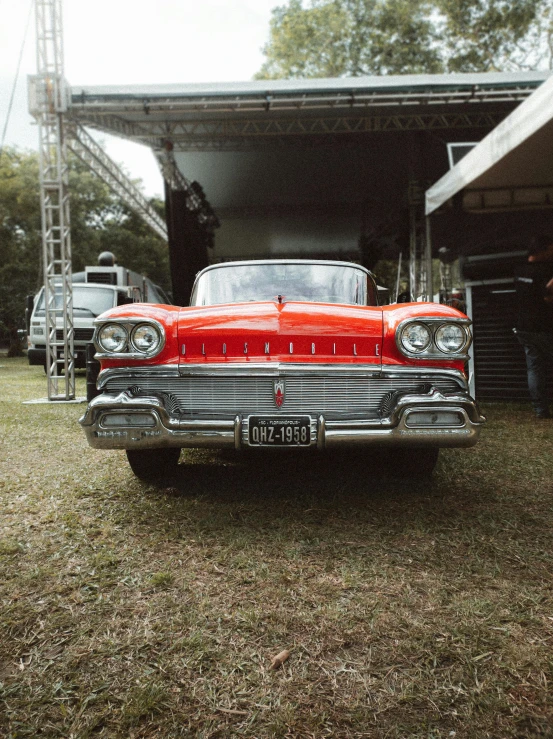 an old red car in front of a house