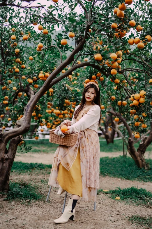 a woman with a basket of fruit standing in the field