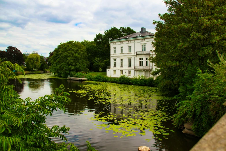 a white building sitting next to a small pond