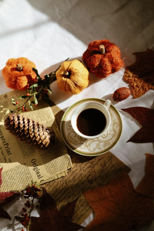 two cups of coffee are on the table with autumn decorations