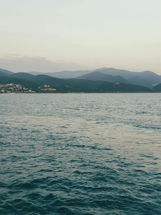 the calm body of water is surrounded by mountains