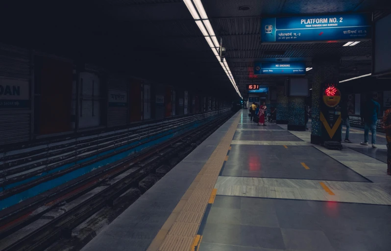 a person stands on a platform while an underground train stops