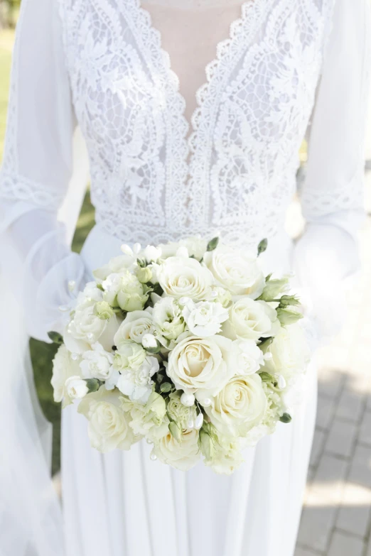 a woman in a white dress is holding a bouquet