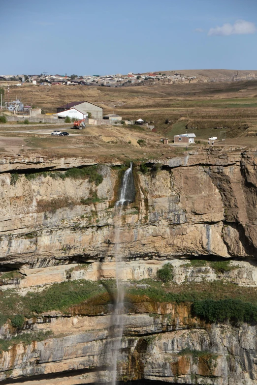 a cliff that has a small waterfall falling from the side of it