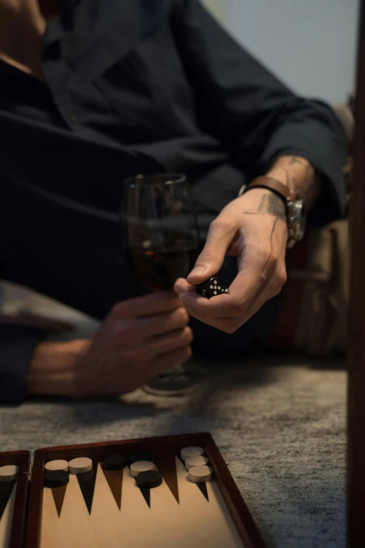 a man sitting on the floor with a glass of wine