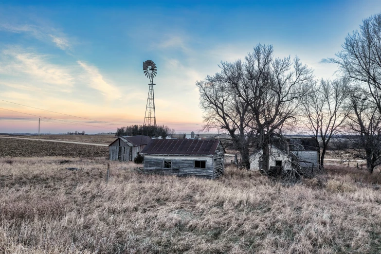 a house in the middle of a field with some trees