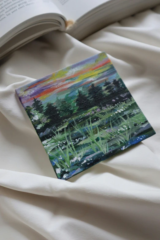 an oil painting of a lush green landscape, is folded over on top of the blanket