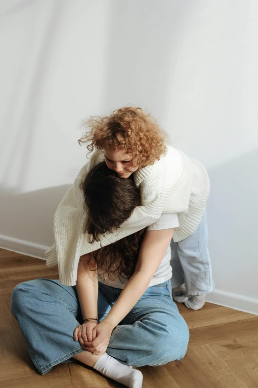 the young man and woman are hugging in the middle of a wooden floor