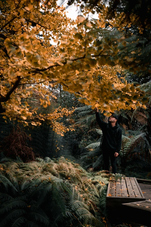 two people standing next to each other in a forest