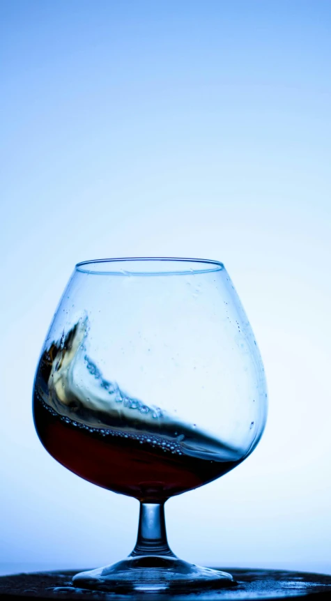 a glass of wine sitting on top of a table