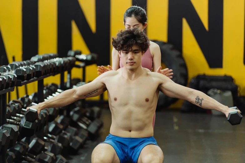 a woman and man are posing for a gym portrait